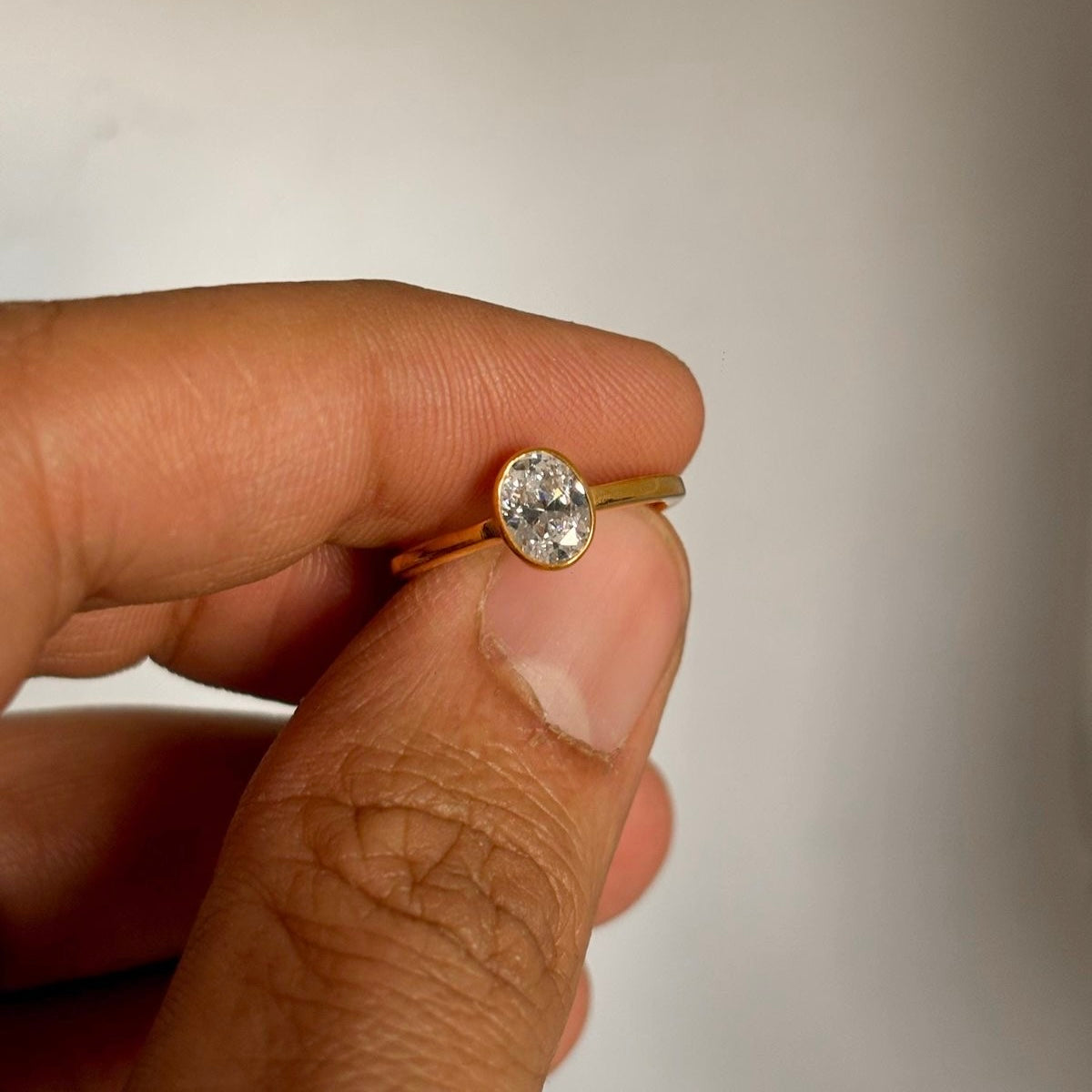 Ovaler Bezel-Verlobungsring mit Labordiamant an der Hand