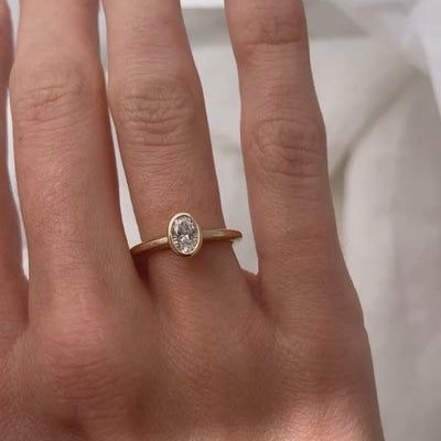 Ovaler Bezel-Verlobungsring mit Labordiamant an der Hand