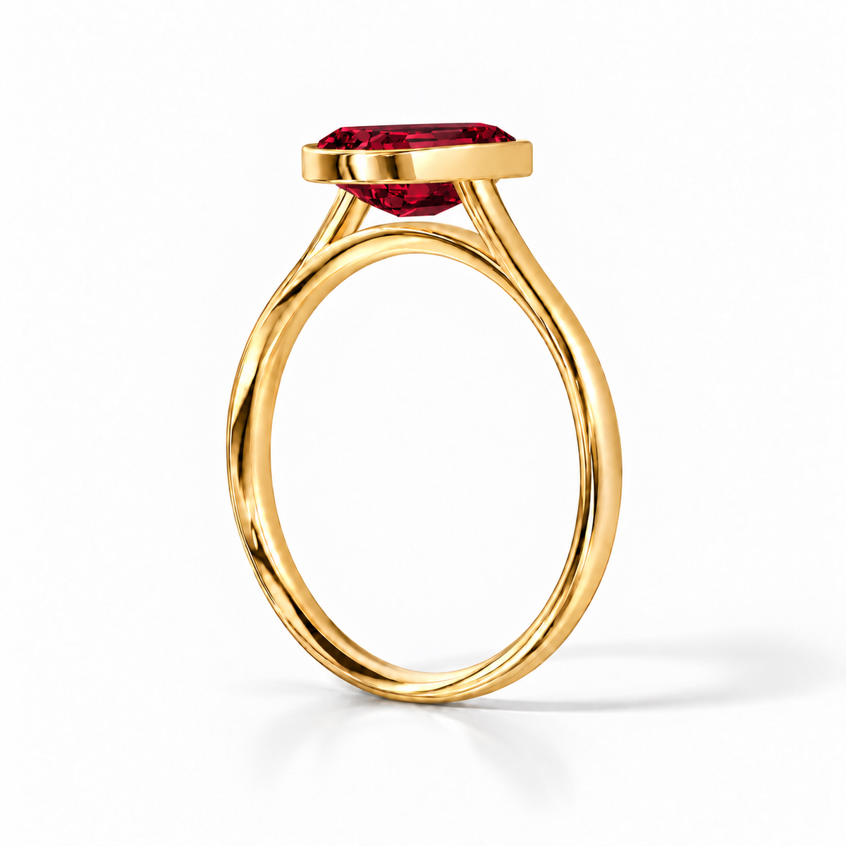 Gia Verlobungsring mit rotem Laborrubin im Emerald-Schliff und Bezel-Fassung in Gelbgold – Schrägansicht auf weißem Hintergrund