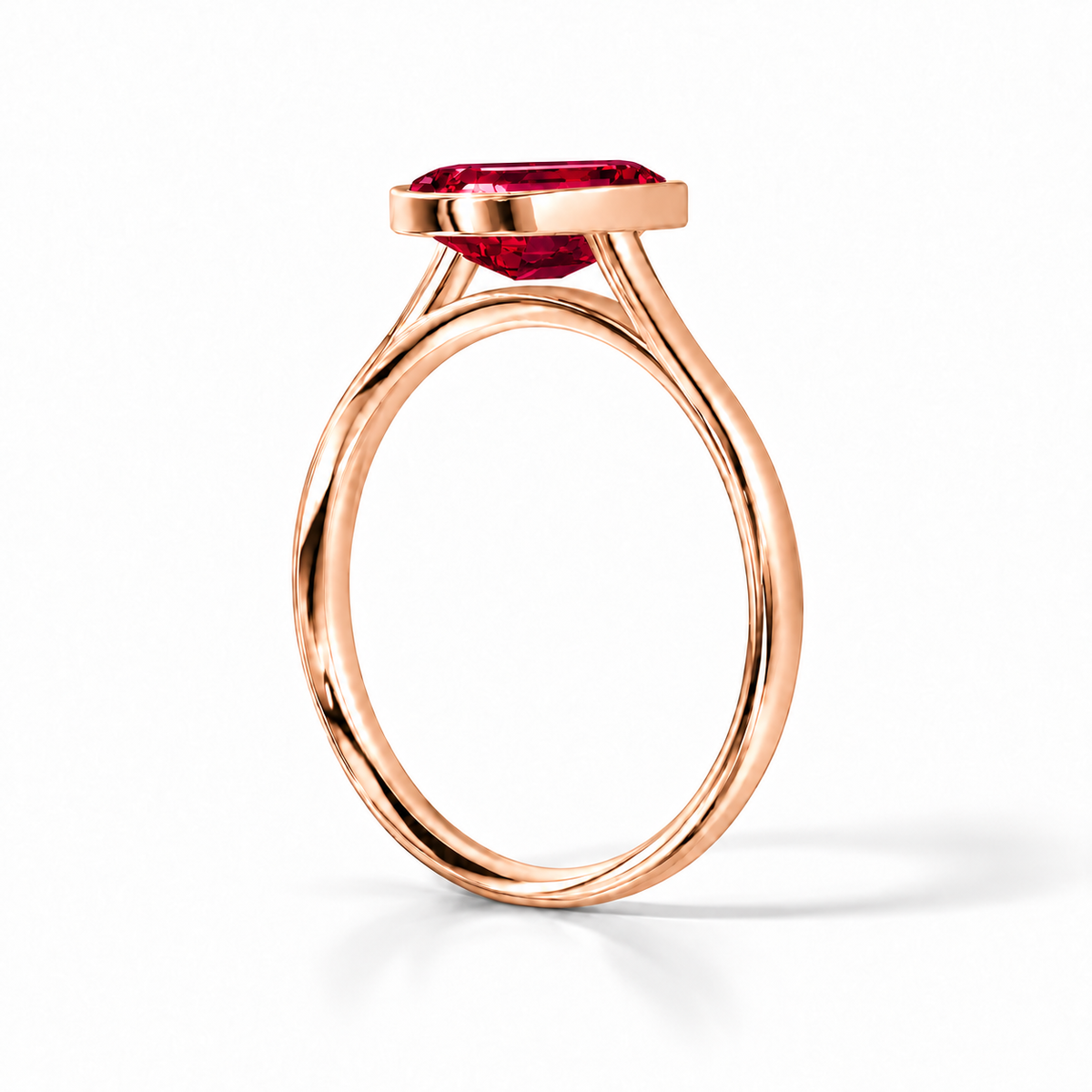 Gia Verlobungsring mit rotem Laborrubin im Emerald-Schliff und Bezel-Fassung in Roségold – Schrägansicht auf weißem Hintergrund