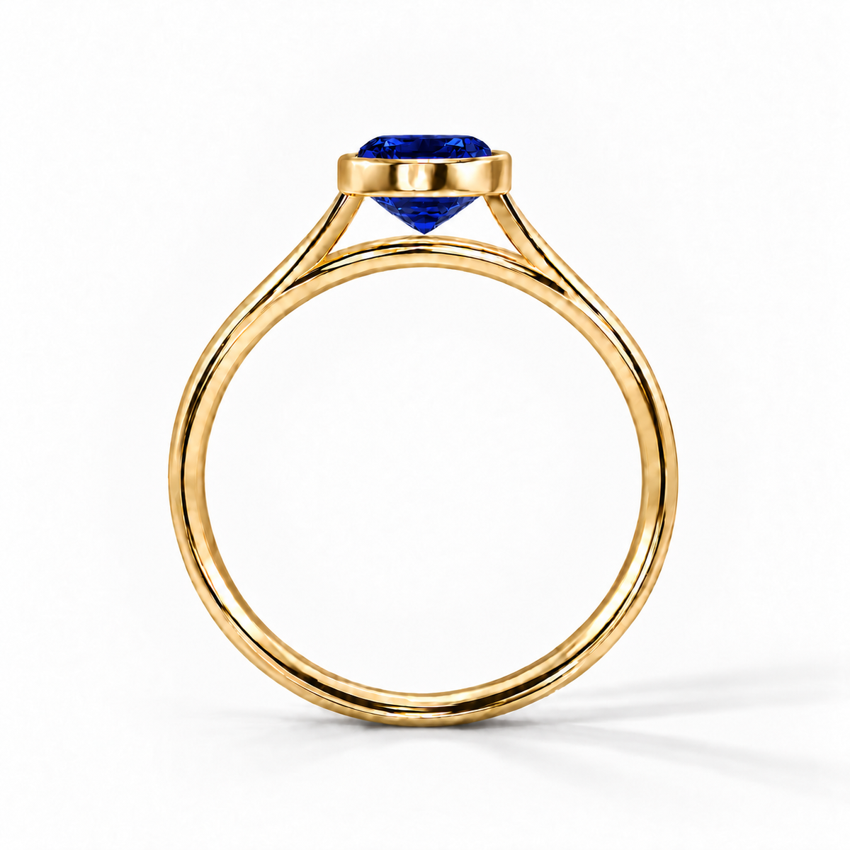 Gia Verlobungsring mit blauem Laborsaphir im Emerald-Schliff und Bezel-Fassung in Gelbgold – Profilansicht auf weißem Hintergrund