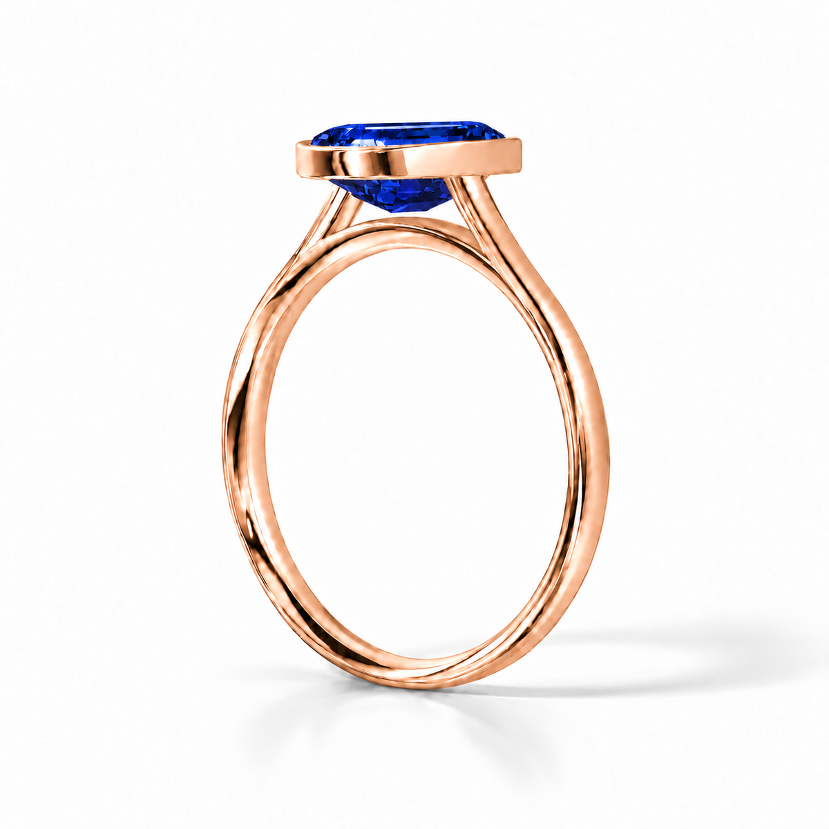 Gia Verlobungsring mit blauem Laborsaphir im Emerald-Schliff und Bezel-Fassung in Roségold – Schrägansicht auf weißem Hintergrund