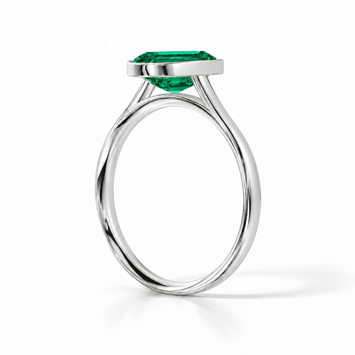 Gia Verlobungsring mit grünem Laborsmaragd im Emerald-Schliff und Bezel-Fassung in Weißgold – Schrägansicht auf weißem Hintergrund
