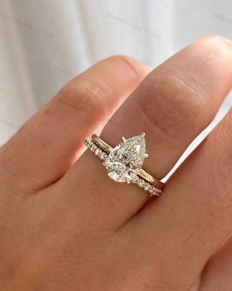 Tropfen-Verlobungsring mit passendem Memoire-Ring an einer Hand