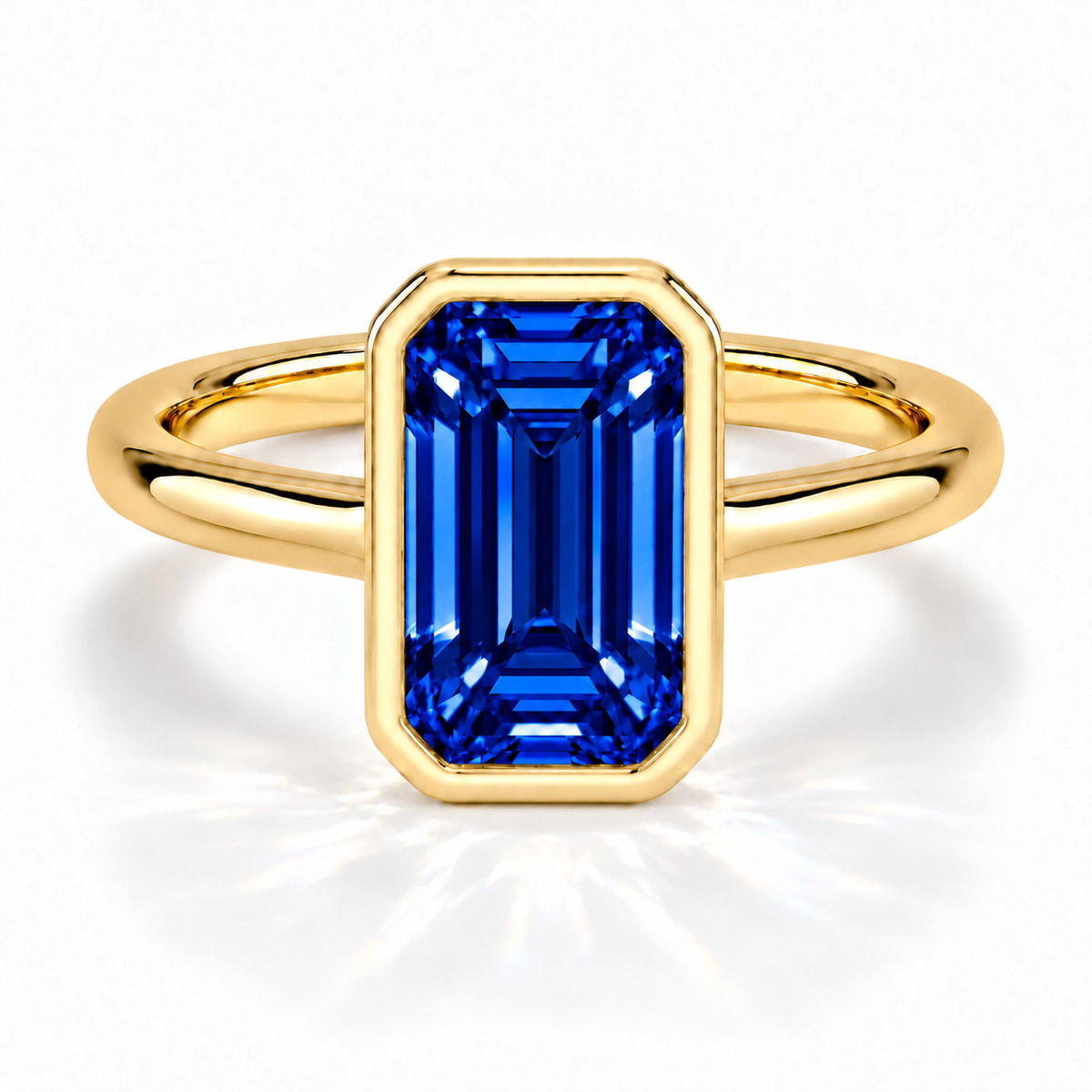 Gia Verlobungsring mit blauem Laborsaphir im Emerald-Schliff und Bezel-Fassung in Gelbgold – Frontalansicht auf weißem Hintergrund
