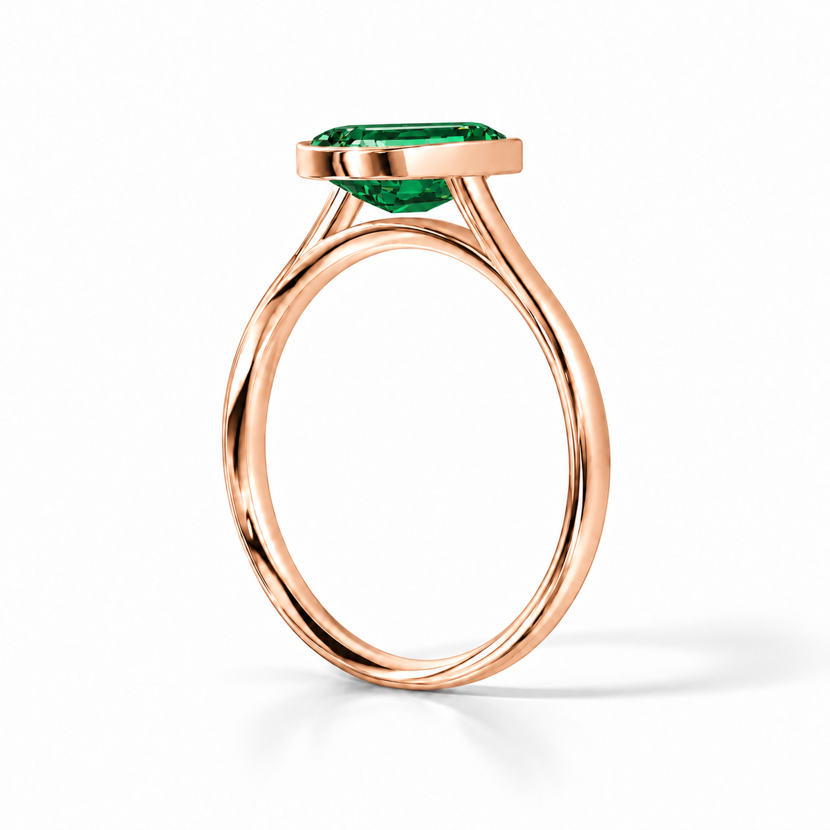 Gia Verlobungsring mit grünem Laborsmaragd im Emerald-Schliff und Bezel-Fassung in Roségold – Schrägansicht auf weißem Hintergrund