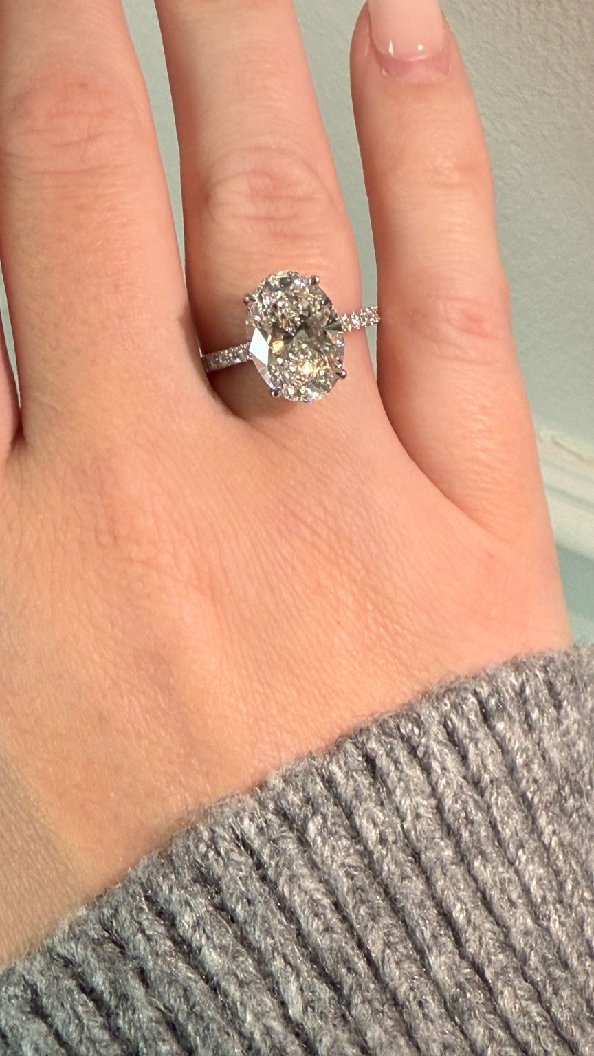 Ovaler Diamantring mit Pavé-Ringschiene an einer Hand