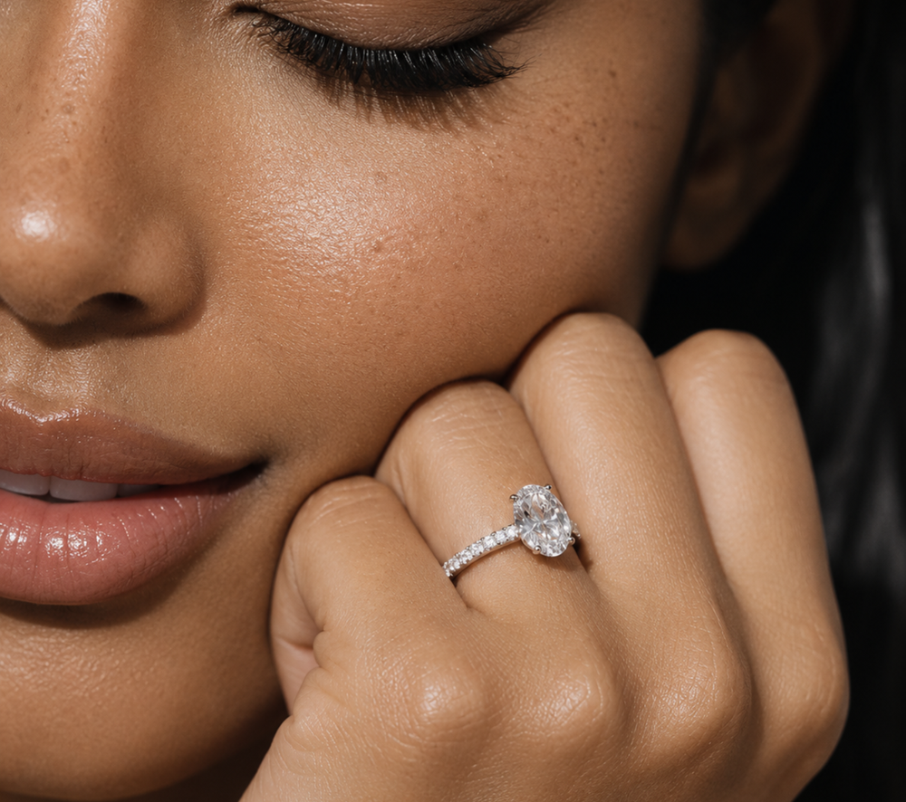 Nahaufnahme einer Frau mit rundem Diamantring und Pavé-Ringschiene